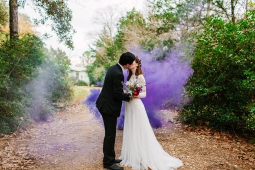 a wedding portrait in the garden accented with a purple smoke bomb is very bold and cool