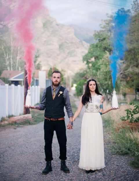 a fun and cool idea of a wedding portrait with a pink and blue smoke bomb to accent the couple