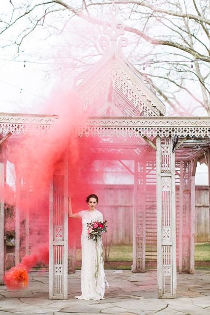 a carved wooden arch accented with a bright pink smoke bomb looks out of this world and fantastic