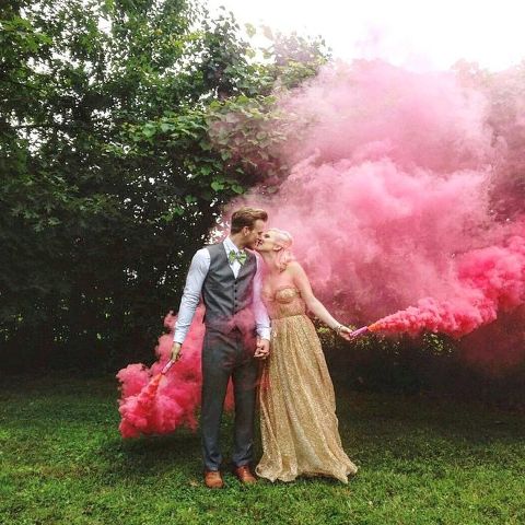hot pink smoke bombs accent the couple and make it stand out in the greenery backdrop