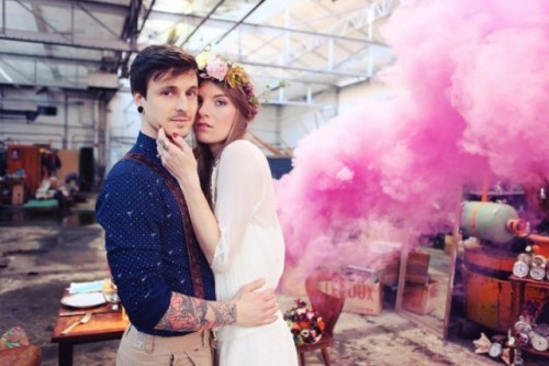an industrial wedding space turned into a romantic one with a pink smoke bomb becomes a lovely backdrop for a wedding portrait