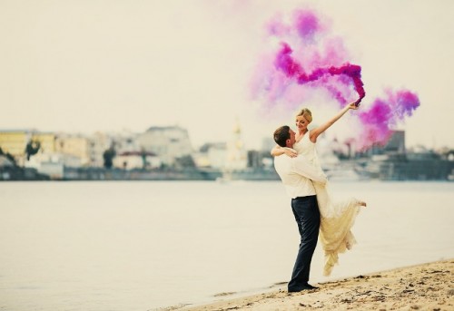 a lovely beach wedding portrait done with a purple smoke bomb looks very bold, catchy and very cool