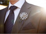 a bold black and white wedding boutonniere with ribbons and buttons is a lovely and fun idea