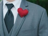 a red heart-shaped boutonniere is a nice way to give a more romantic and whimsy touch to a groom’s look