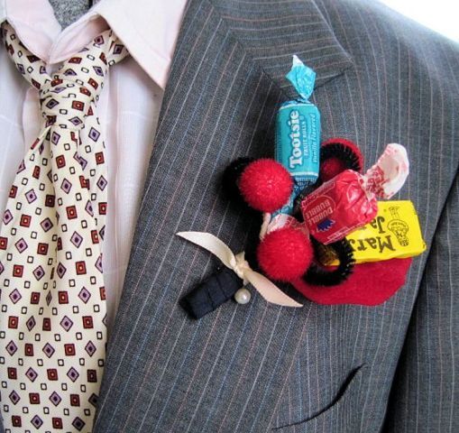 a colorful candy and pompom wedding boutonniere with a ribbon wrap is a nice and fun idea to try