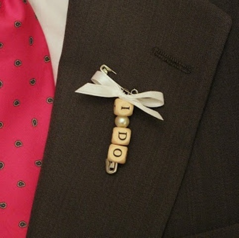 a scrubble wedding boutonniere with a pin, a bead and a ribbon bow is lovely and easy to DIY