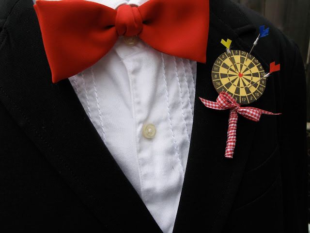 a colorful darts boutonniere with bright arrows and ribbon is a fun and playful accessory idea