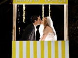 a bold yellow and white kissing booth with a stripe pattern is a fun idea for a modern wedding