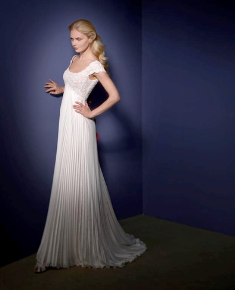 a refined A-line wedding dress with a lace bodice and cap sleeves and a pleated skirt with a train looks vintage-like
