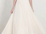 an a-line wedding dress with a pleated semi sheer overdress and a gold belt for a refined and chic look
