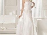 a vintage-inspired wedding dress with a semi sheer overdress, a high neckline and pleating is a refined idea