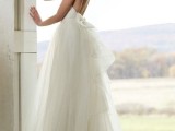 an ivory wedding ballgown with a lace bodice, a layered skirt with a train and an open back