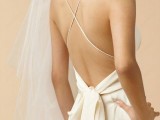 a fitting spaghetti strap wedding dress with a criss cross open back and a bow on the back