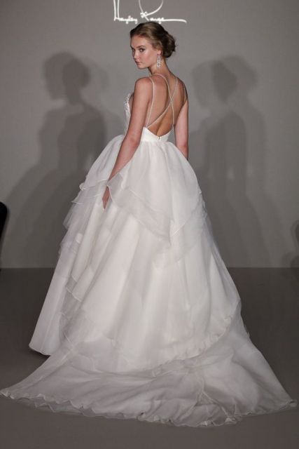 a wedding ballgown with an open back, criss cross spaghetti straps and a full layered skirt with a train