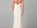 a neutral sheath wedding dress with spaghetti straps, an open back and a draped skirt and a train