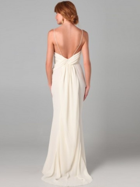 a neutral sheath wedding dress with spaghetti straps, an open back and a draped skirt and a train