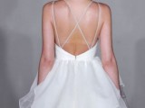 a romantic white wedding ballgown with a sleek bodice, a layered skirt and spaghetti straps and an open back