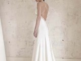 a sleek A-line wedding dress with a lace edge, spaghetti straps, an open back with a criss cross and a train