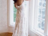a boho lace fitting wedding dress with spaghetti straps and an open back and a large bow on the back