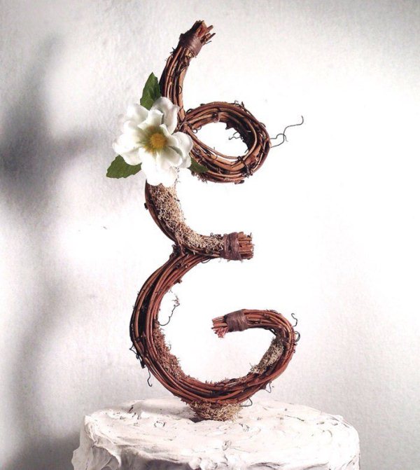 A vine monogram with a single white bloom is a creative and cool wedding cake topper to try