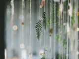 a tiered wedding garland with fresh greenery, metallic polka dots and feathers is a cool decoration for a boho wedding