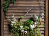 a lovely nature-inspired wreath of a wire form and moss, natural greenery and branches is a lovely woodland wedding decoration to rock
