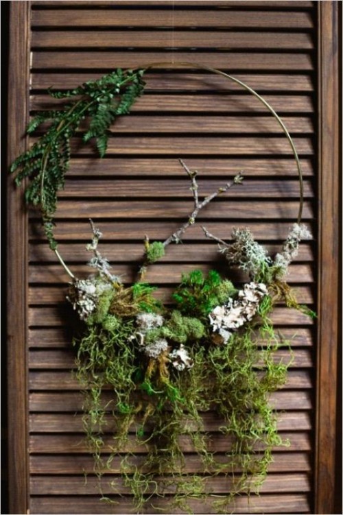 a lovely nature-inspired wreath of a wire form and moss, natural greenery and branches is a lovely woodland wedding decoration to rock