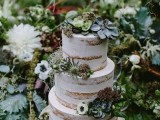 a semi naked wedding cake topped with greenery and succulents plus thistles and greenery is a cool idea for a boho or woodland wedding