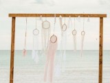 a wooden wedding arch with an arrangement of crochet and lace dream catchers looks dreamy and very chic