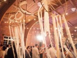 oversized crochet dreamcatchers with long fabric fringe are used to decorate the dance floor
