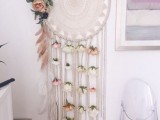 a crochet dream catcher decorated with romantic pastel blooms and long fringe is a proper decoration for a wedding