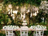 dream catchers with feathers and bulbs hanging over the reception table is a cool way to add a boho touch to the space