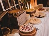 a vintage rustic pie bar with vintage window frames, crates and boxes, some wildflowers, plates and some pies to make everyone happy