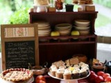 a cozy fall pie bar with crates and boxes, a chalkboard menu, apples and candies, lots of plates and mini pies is great for a fall wedding