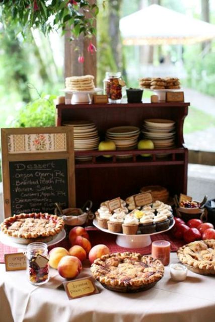 a cozy fall pie bar with crates and boxes, a chalkboard menu, apples and candies, lots of plates and mini pies is great for a fall wedding