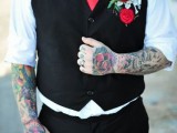 a colorful and contrasting groom’s look with a white shirt, a black waistcoat and black pants, a red tie and a red bloom boutonniere