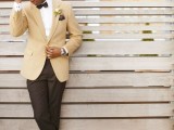 an elegant groom’s outfit with black pants, a white shirt, a buttermilk jacket, a matching hat