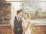 a vintage groom’s look with black pants, a black waistcoat, a red tie, a grey cap