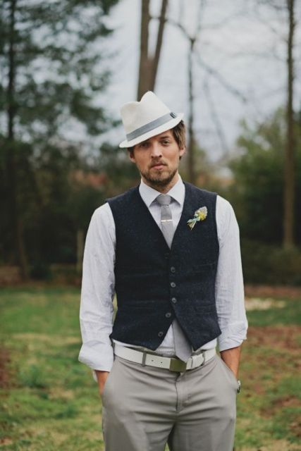 grey pants and a tie, a white shirt, a black waistcoat, a white shirt and a neutral hat