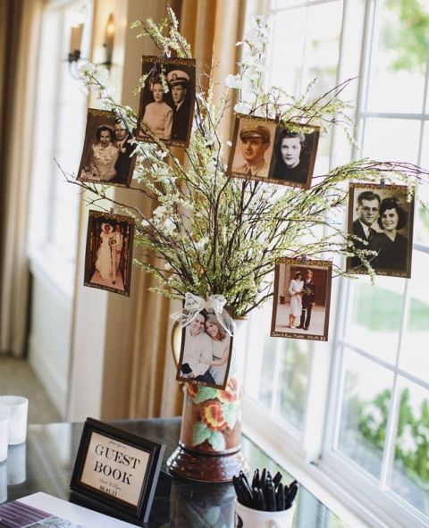 blooming branches in a whimsy vase with leaves and blooms plus vintage family photos on them for a spring wedding