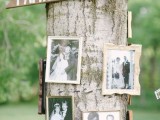 a real tree with black and white family pics on it is a simple and natural idea for an outdoor wedding