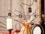 blooming branches with family photos put into a vase wrapped with fabric and secured with a bow for a fall wedding