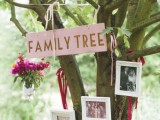 a real tree with a sign and some family photos plus blooms in a vase hanging down is a cozy and natural idea
