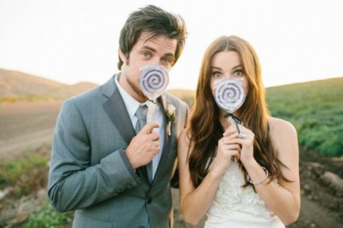 pretty lollipops used for fun wedding portraits are a lovely idea for a wedding