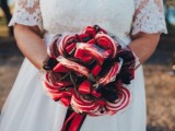 a quirky wedding bouquet of red and white lollipops and black bows is a lovely and catchy idea for a Halloween wedding