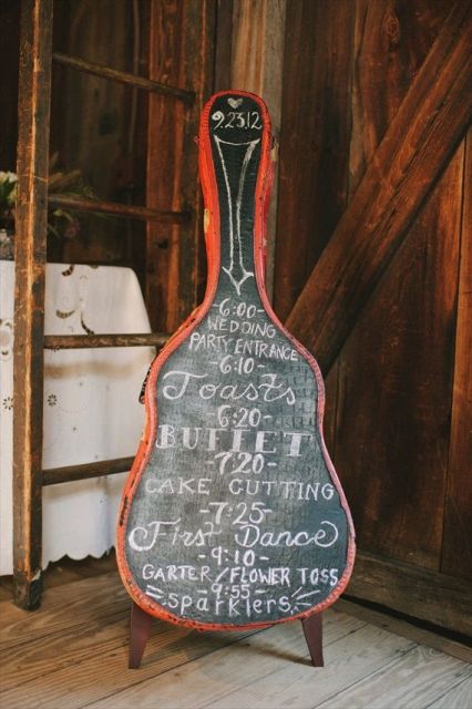 a chalkboard sign shaped as a guitar is a cool sign idea for a modern wedding and it shows off your interests