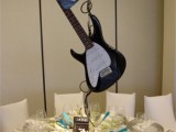 a guitar wedding centerpiece with some neutral blooms under it will make your wedding reception table cooler and bolder