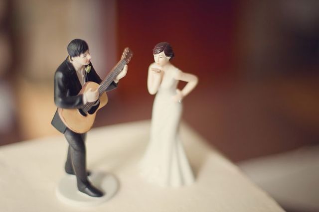 Cool wedding cake toppers   a groom playing the guitar and a bride is a very whimsical idea