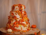 a white wedding cake covered with bold faux leaves is a bright and cool solution for a fall wedding, it will match any style