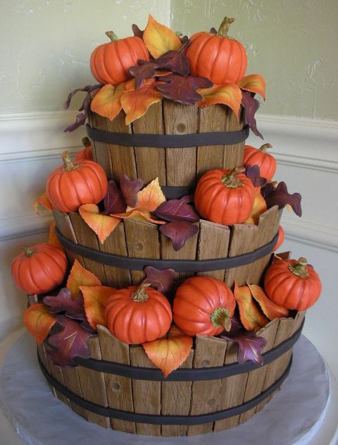 a unique wedding cake showing wooden baskets with leaves and pumpkins is really a creative idea for a rustic fall wedding
